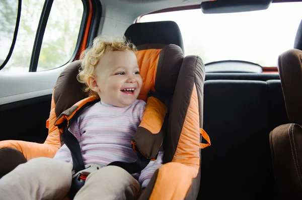 Счастливый ребенок улыбается в сиденье автомобиля — стоковое фото