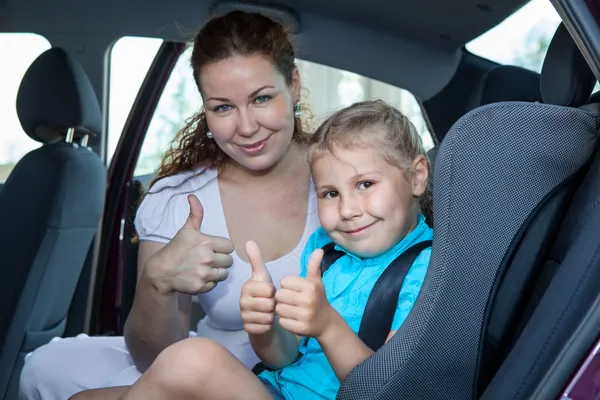 Мать и ребенок, показывая пальцем вверх жест в автомобильное кресло — стоковое фото