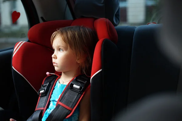Ребенок в авто ребенке фиксируется в автомобиле — стоковое фото